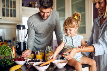 Cute little girl with parents preparing breakfast