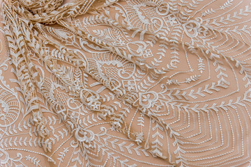 Texture lace fabric. lace on beige background studio. thin fabric made of yarn or thread. typically...