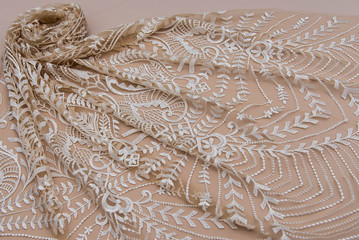 Texture lace fabric. lace on beige background studio. thin fabric made of yarn or thread. typically...