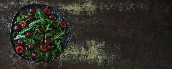 Obraz na płótnie Canvas Healthy salad arugula sweet cherry. Raw diet concept. Summer fitness salad.