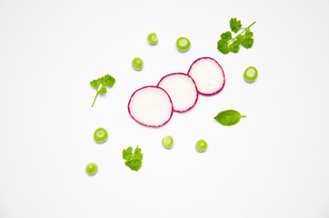 sliced radish peas seeds and parsley on white background