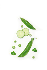 peas and sliced cucumber and parsley on white background