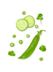 peas and sliced cucumber and parsley on white background