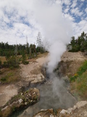 Dragon's Mouth Spring, a turbulent hot spring with water sloshing in and out of the cavern at Yellowstone National Park.