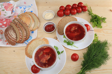 Traditional Russian borsch with egg and bread on a wooden table. Delicious traditional natural food, top view, selective focus.