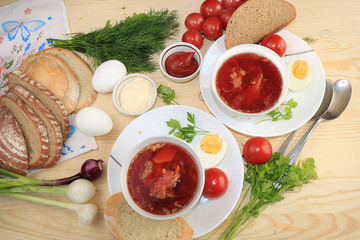Traditional Russian borsch with egg and bread on a wooden table. Delicious traditional natural food, top view, selective focus.