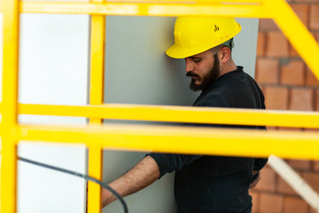 Worker builds a plasterboard wall.