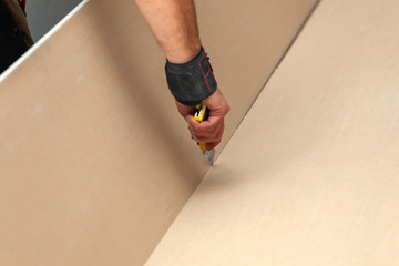 Worker builds a plasterboard wall.