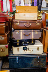 A stack of old and vintage suitcases, steamer trunks and wooden boxes on display for sell at...