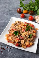 Soba noodles with vegetables and shrimps - asian food creative concept.