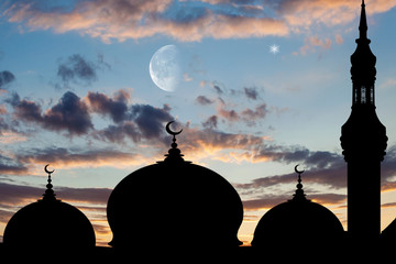 Silhouette of big mosque with high minaret at sunset