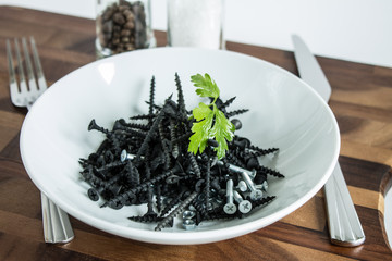 Black metal nails on a white plate