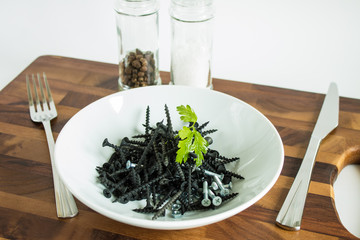 Black metal nails on a white plate