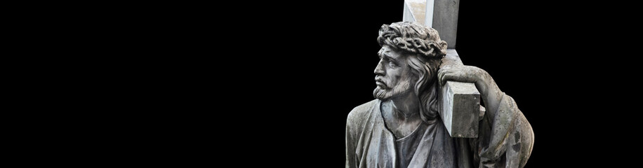 The crucifixion of Jesus Christ  in profile. Antique statue isolated on black background.