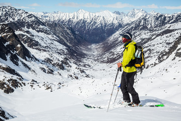 Fototapeta na wymiar Skier standing above Snowbird Glacier looking down Bartholf Creek in Talkeetna Mountains