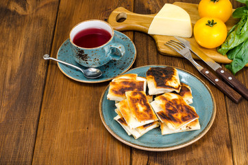 Fried pita bread filled with cheese, tomato and greens