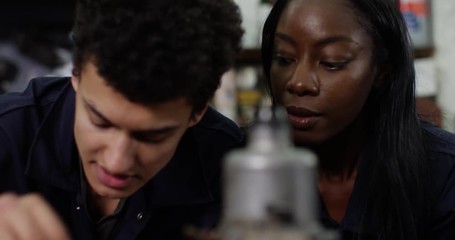 4K Close up smiling mechanics in garage workshop rebuilding vehicle engine