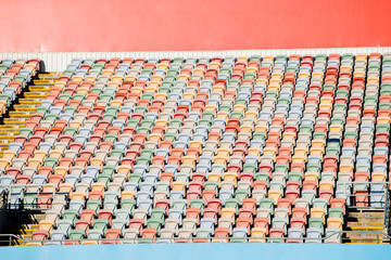 Empty multi-colored seats at a sporting venue.