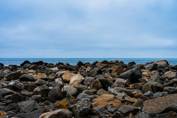 Fototapeta na wymiar Rocks fronting the coast of the Pacific Ocean's horizon.