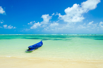 Lonely boat moored on a dreamy paradise beach.