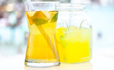 Fresh delicious green tea with apple and lemonade on the sea background.
