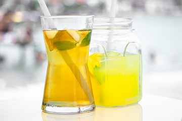 Fresh delicious green tea with apple and lemonade on the sea background.