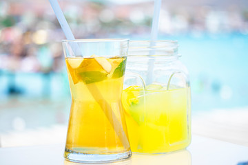 Fresh delicious green tea with apple and lemonade on the sea background.