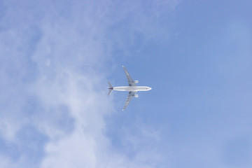 An airplane on the cloudy blue sky