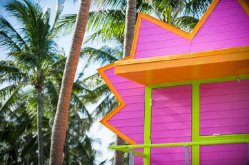Bright scenic view of colorfully painted lifeguard tower with palm trees in South Beach, Miami, Florida, USA