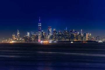 Obraz premium Panoramę Nowego Jorku na Manhattanie oświetlone światłami o zmierzchu po zachodzie słońca, widok z New York Bay i Staten Island, widok na wodę