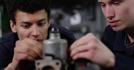 4K Young smiling mechanics in garage workshop working on engine repairs