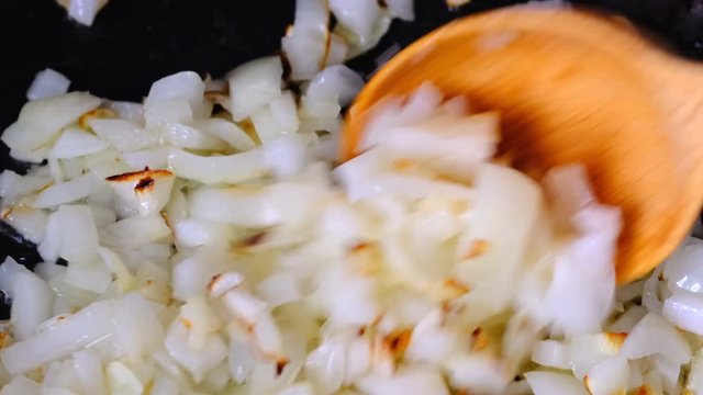White onion sliced into small pieces, passed with olive oil on a teflon pan with non-stick coating, video clip close-up shooting