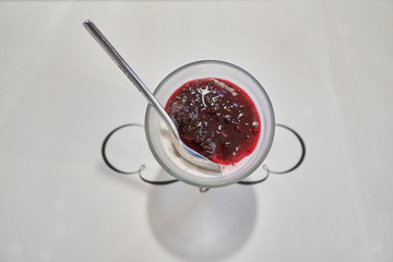 A delicious and sweet cranberry yogurt dessert served in a small bowl with a silver spoon.