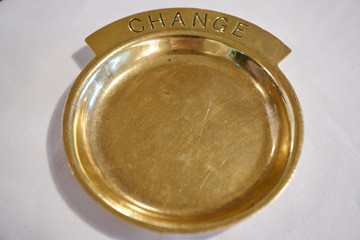A gold colored metal  decoration used for placiing coins.