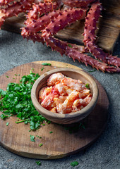 Crab meat of king crab in wooden bowl on gray background