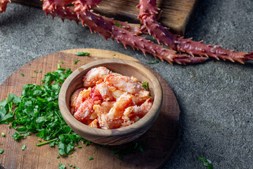 Crab meat of king crab in wooden bowl on gray background