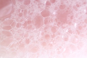 pink soap foam macro background.soap bubbles gently pink pastel color with a white gradient. Bath...