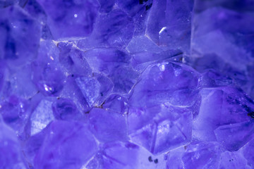 Isolated close up macro of an amethyst crystal lite in blue light