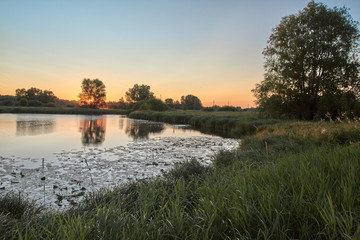 Beautiful sunrise on the lake, the path of the Sun burns with gold