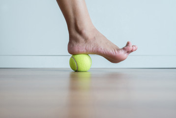 Woman massage with tennis ball to foot,Feet soles or heel massage for plantar fasciitis