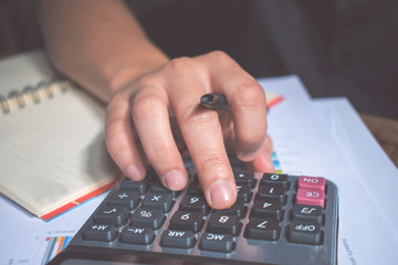 Asian, A man wearing black shirt are calculating numbers from the graph.