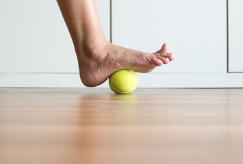 Woman massage with tennis ball to foot,Feet soles massage for plantar fasciitis