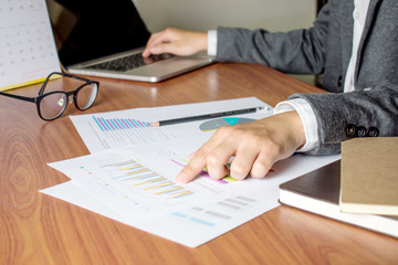 Businessmen are recording information on a computer in the office.