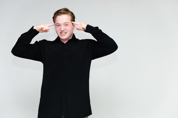 Portrait to the waist on a white background of a handsome young man in a black shirt. stands directly in front of the camera in different poses, talking, showing emotions, showing hands.