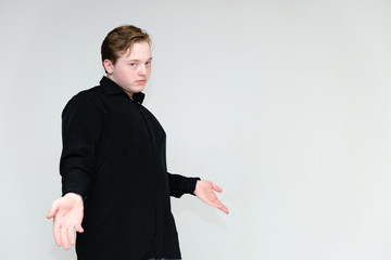 Portrait to the waist on a white background of a handsome young man in a black shirt. stands directly in front of the camera in different poses, talking, showing emotions, showing hands. - Powered by Adobe