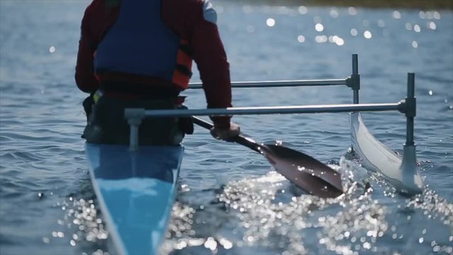 Back view of Disabled athlete using paddle in a canoe. Rowing, canoeing, paddling. Training. Kayaking. paraolympic sport. canoe for disabled people.