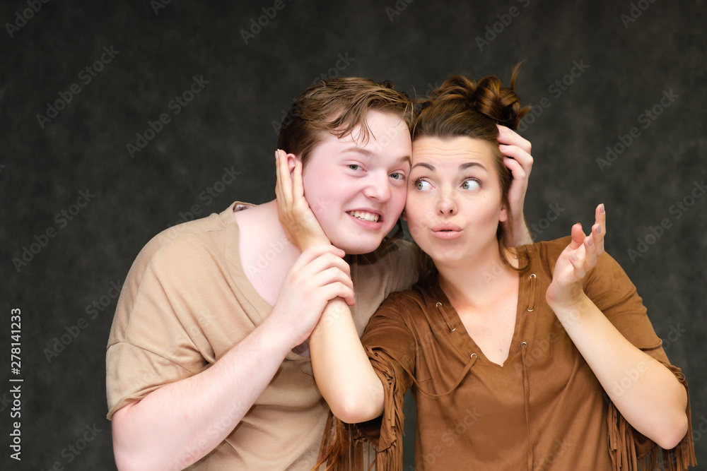 Wall mural a portrait below the belt on a gray background of a pretty young brunette woman in a brown dress and