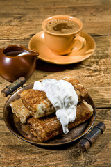 Cup of coffee and pancakes with cream