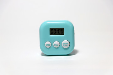 Green blue color of square shape plastic stopwatch on the white floor.