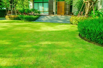 Fotobehang Groen gras, modern huis met mooi aangelegde voortuin, gazon en tuin vervagen achtergrond., het ontwerpconcept voor achtergrond, tuin met groen gazon en tuin © singjai